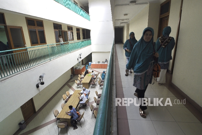  Sejumlah calon jamaah haji berjalan keluar dari kamar jamaah di Gedung Asrama Haji Pondok Gede, Jakarta. 