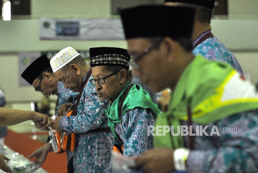 Sejumlah calon jamaah haji kloter satu melakukan pengecekan indentitas sebelum bersiap untuk berangkat ke tanah suci di Asrama Haji Pondok Gede, Jakarta, Kamis (27/7).