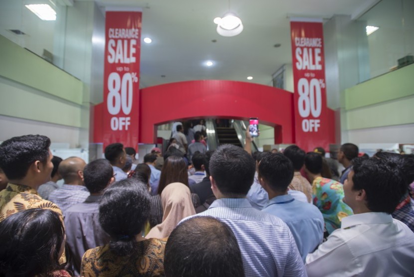 Sejumlah calon pembeli berdiri mengantre di depan pintu masuk pusat perbelanjaan Lotus untuk berbelanja barang dengan potongan harga di Jalan K.H. Wahid Hasyim, Jakarta Pusat, Rabu (25/10). 