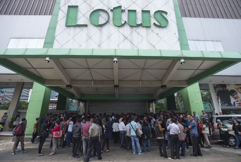 Sejumlah calon pembeli berdiri mengantre di depan pintu masuk pusat perbelanjaan Lotus yang masih tertutup untuk berbelanja barang dengan potongan harga di Jalan K.H. Wahid Hasyim, Jakarta Pusat, Rabu (25/10). 