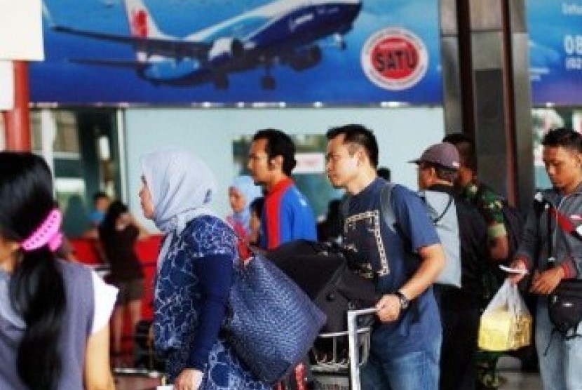 Sejumlah calon penumpang antre melewati pemeriksaan tiket di Terminal 1, Bandara Soekarno-Hatta, Cengkareng, Banten, Ahad (28/8). 