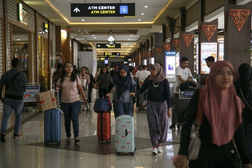 Sejumlah calon penumpang berjalan menuju terminal keberangkatan Bandara Adisutjipto, Sleman, DI Yogyakarta, Senin (24/12/2018).