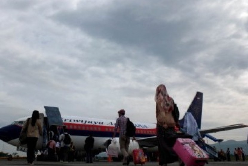 Sejumlah calon penumpang berjalan meuju pesawat komersil di Bandara Abdul Rachman Saleh, Malang , Jawa Timur, Senin (19/3). (Republika/Prayogi)