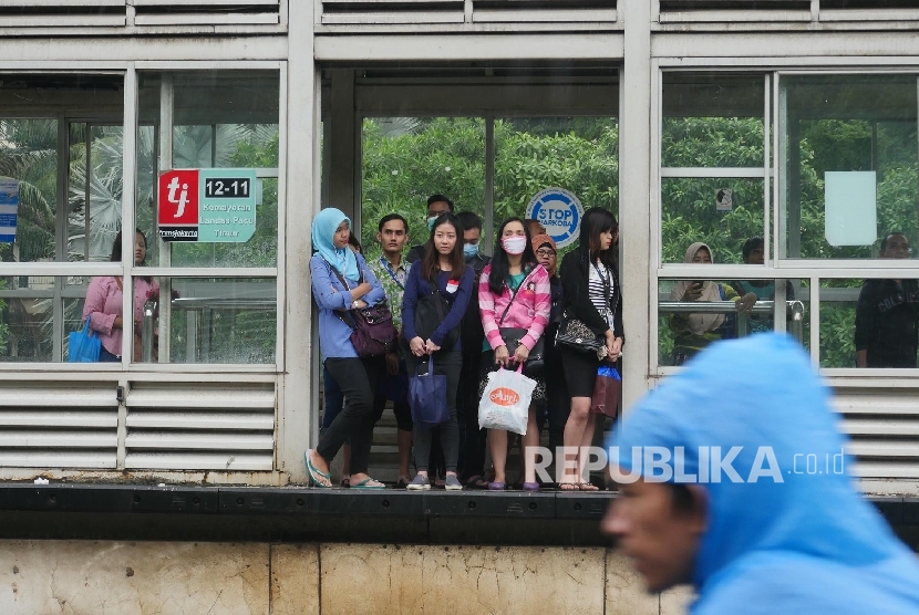 Sejumlah calon penumpang Bus Way Nampak menunggu datangnya Busway yang sedikit terhambat kedatangannya di halte bus way Kemayoran Landas Pacu Timur, Jakarta, Selasa (21/2).