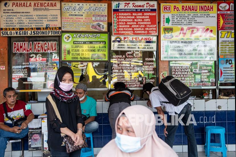 Sejumlah penumpang dengan mengenakan masker menunggu di depan loket Terminal Kalideres, Jakarta Barat, Senin (26/4/2021). 