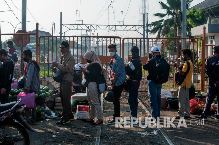 Sejumlah calon penumpang KRL Commuter Line antre hingga ke jalan raya di Stasiun Rangkasbitung, Lebak, Banten.