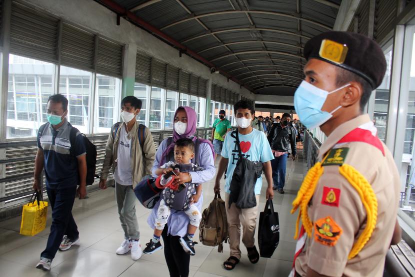 Sejumlah calon penumpang membawa barang bawaannya menuju bus di Terminal Bungurasih, Sidoarjo, Jawa Timur, Sabtu (30/4/2022). Pada H-2 Lebaran, puncak arus mudik di terminal Bungurasih tersebut dipadati penumpang yang didominasi karyawan pabrik dan swasta untuk pulang kampung ke sejumlah daerah di Jawa Timur. 