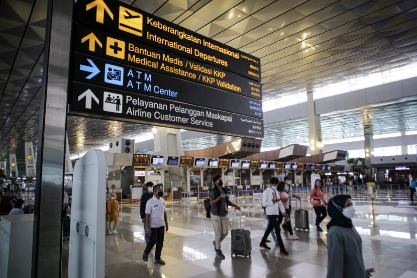 Sejumlah calon penumpang pesawat berjalan di Terminal 3 Bandara Internasional Soekarno-Hatta, Tangerang, Banten, Ahad (16/1/2022). Organisasi Kesehatan Dunia (WHO) telah merekomendasikan pencabutan atau pelonggaran larangan lalu lintas internasional. 