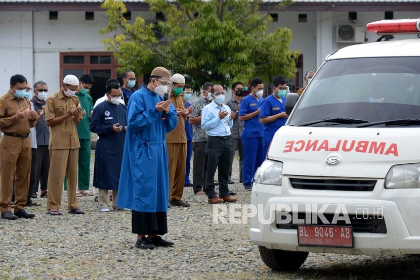 Sejumlah dokter bersama tenaga medis lainnya berdoa setelah melaksanakan shalat jenazah dokter spesialis paru positif Covid-19 saat pelepasan terakhir menggunakan mobil ambulans di RSUD Zainainal Abidin, Banda Aceh, Aceh, Selasa (29/9/2020). Masyarakat diminta ikut lindungi dokter dengan menjalankan protokol kesehatan.
