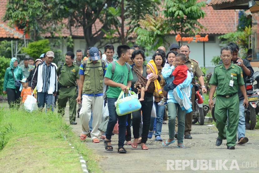 Sejumlah eks Gafatar berjalan menuju bis untuk pulang kampung di Balai Pemberdayaan Sosial Bina Remaja (BPSBR) Dinas Sosial Jabar di Cibabat, Kota Cimahi, Senin (1/2).