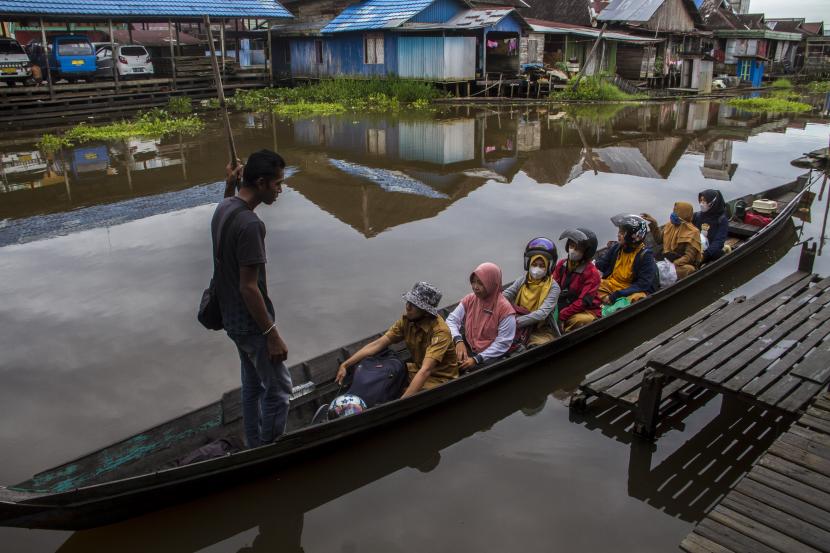 Sejumlah guru berada di atas perahu bermesin saat menuju ke SD Negeri 3 Sungai Buluh di Kecamatan Labuan Amas Utara, Kabupaten Hulu Sungai Tengah, Kalimantan Selatan, Selasa (12/7/2022). 