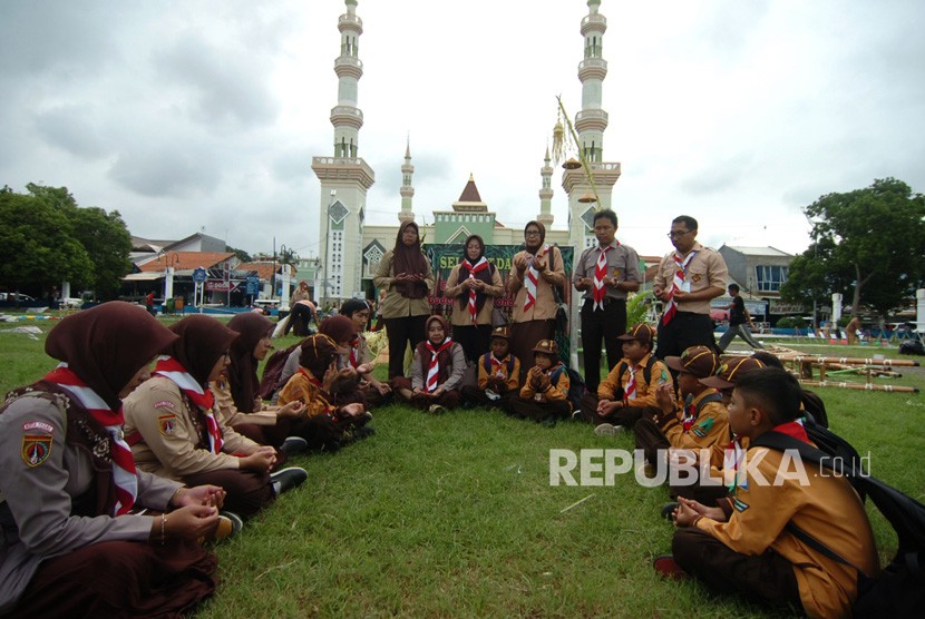Sejumlah guru dan anggota pramuka melaksanakan doa bersama untuk korban susur sungai SMPN 1 Turi, Sleman di Alun-alun Tegal, Jawa Tengah, Sabtu (22/2/2020).