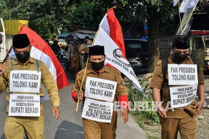 Sejumlah Guru honorer melakukan aksi jalan kaki menuju Istana Negara untuk bertemu Presiden Joko Widodo di Cikarang, Kabupaten Bekasi, Jawa Barat, Senin (26/4/2021). Aksi jalan kaki tersebut menuntut pembayaran gaji guru honorer yang belum dibayarkan Dinas Pendidikan Kabupaten Bekasi dari Bulan Januari 2021.