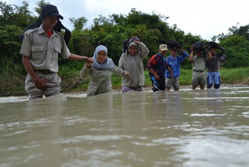 Sejumlah guru SDN Pojok Klitih III bergandengan tangan ketika melewati sungai saat berangkat mengajar di desa terpencil, Kabupaten Jombang, Jawa Timur. (Ilustrasi)