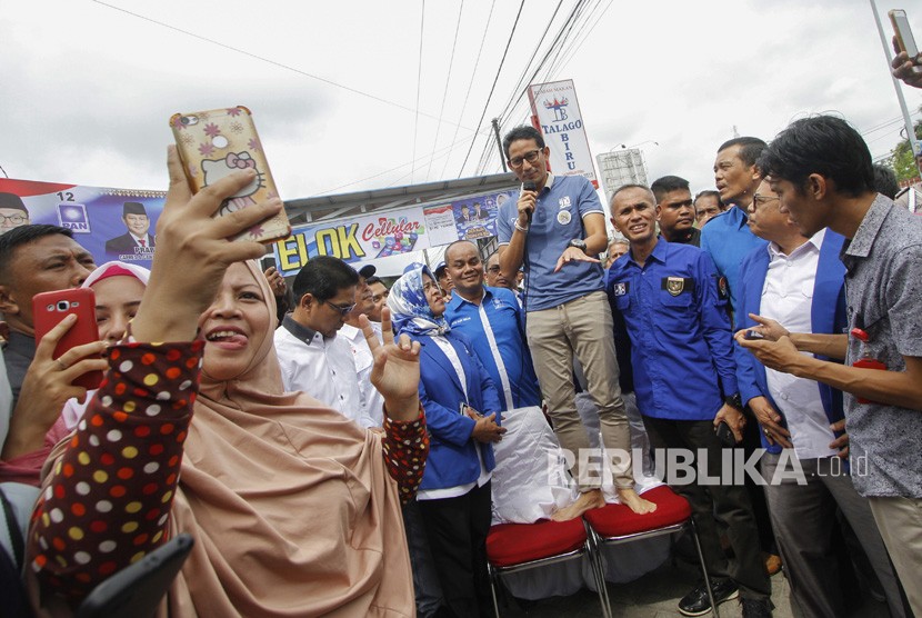 Sejumlah ibu-ibu berswafoto saat Calon Wakil Presiden nomor urut 02 Sandiaga Salahudin Uno (tengah) melakukan dialog di Pasar Selasa, Kota Pekanbaru, Riau, Senin (12/11/2018). 