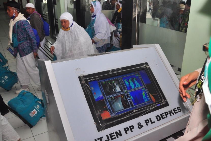 Sejumlah jamaah haji melewati alat pendeteksi suhu tubuh setibanya di tanah air di Embarkasi Donohudan, Boyolali, Jawa Tengah, Kamis (1/10). 