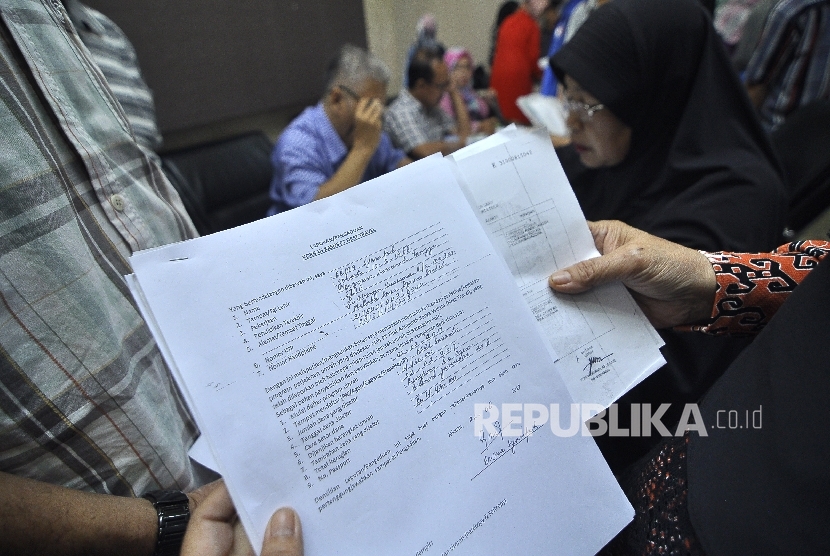 Sejumlah jamaah korban dugaan penipuan perjalan umrah First Travel memperlihatkan formulis pengaduan di Kantor Bareskrim Polri Gambir, Jakarta Pusat, Selasa (22/8).