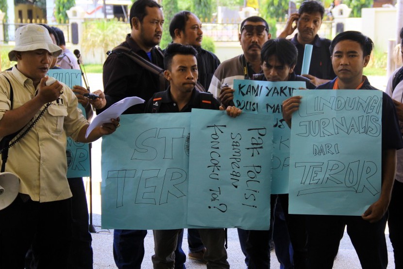 Sejumlah jurnalis melakukan aksi unjuk rasa di depan Mapolres Banyuwangi, Jawa Timur, Senin (9/11). 