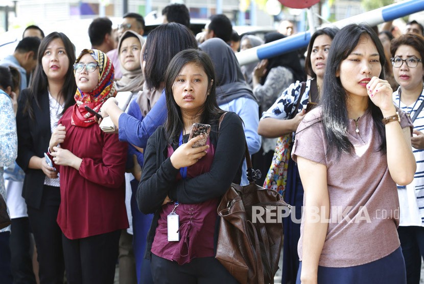 Sejumlah karyawan berkumpul di luar gedung pasca gempa yang mengguncang Jakarta, Selasa (23/1).