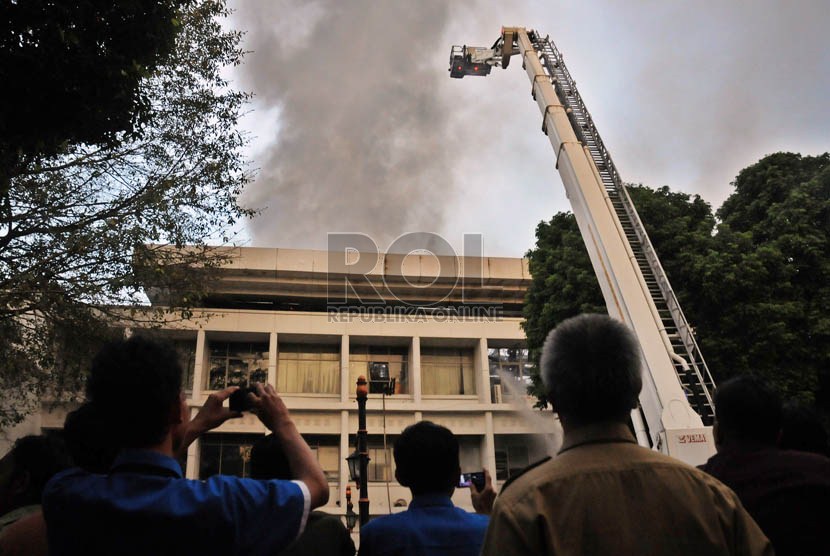  Sejumlah karyawan Istana Negara menyaksikan petugas memadamkan api kebakaran lantai tiga Gedung Sekretariat Negara di Kompleks Istana Negara, Jakarta, Kamis (21/3) sore. (Republika/Aditya Pradana Putra)