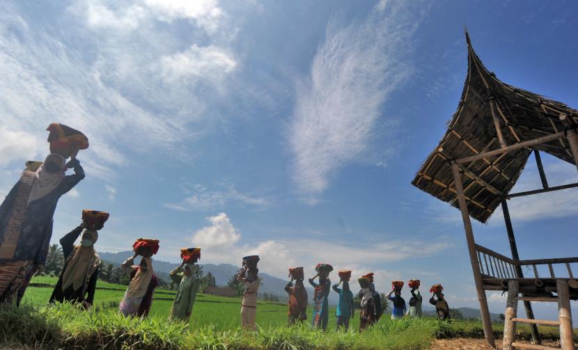Sejumlah kaum ibu menggunakan masker, membawa baki di kepala mereka, saat digelarnya Festival Budaya Batipuh, di Batang Gadih, Nagari Batipuh Baruah, Kec.Batipuh, Kab.Tanah Datar, Sumatera Barat, Sabtu (15/8/2020). Festival budaya tersebut digelar dengan tetap mematuhi protokol COVID-19. 