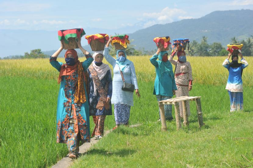 Sejumlah kaum ibu menggunakan masker, membawa baki di kepala mereka, saat digelarnya Festival Budaya Batipuh, di Batang Gadih, Nagari Batipuh Baruah, Kec.Batipuh, Kab.Tanah Datar, Sumatra Barat, Sabtu (15/8/2020). Tanah Datar mengonfirmasikan total 110 kasus Covid-19 pada Sabtu (5/9).