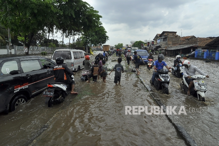   Sejumlah kedaraan berusaha melintasi banjir di kawasan Jalan Raya Rancaekek di depan Pabrik PT Kahatek, Kabupaten Bandung, Jawa Barat, Selasa (1/11).(Republika/Mahmud Muhyidin)