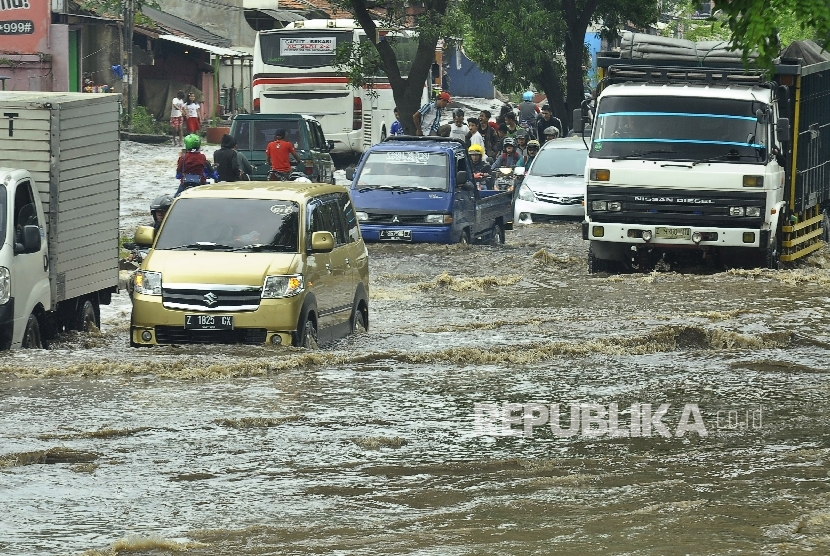  Sejumlah kedaraan berusaha melintasi banjir di kawasan Jalan Raya Rancaekek di depan Pabrik PT Kahatek, Kabupaten Bandung, Jawa Barat, Selasa (1/11). (Republika/Mahmud Muhyidin)