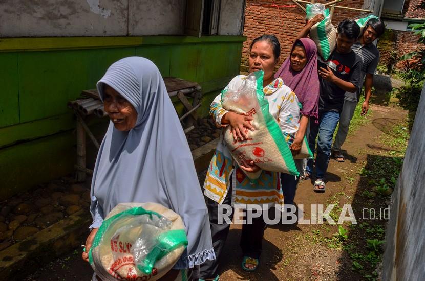 Sejumlah Keluarga Penerima Manfaat (KPM) membawa beras bansos Bantuan Pangan Non-Tunai (BPNT) (ilustrasi). 