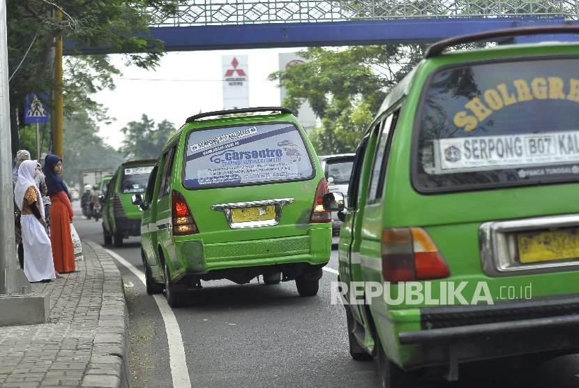 Sejumlah kendaraan angkutan kota (angkot) menunggu penumpang datang di ruas Jalan Daan Mogot, Tangerang. 