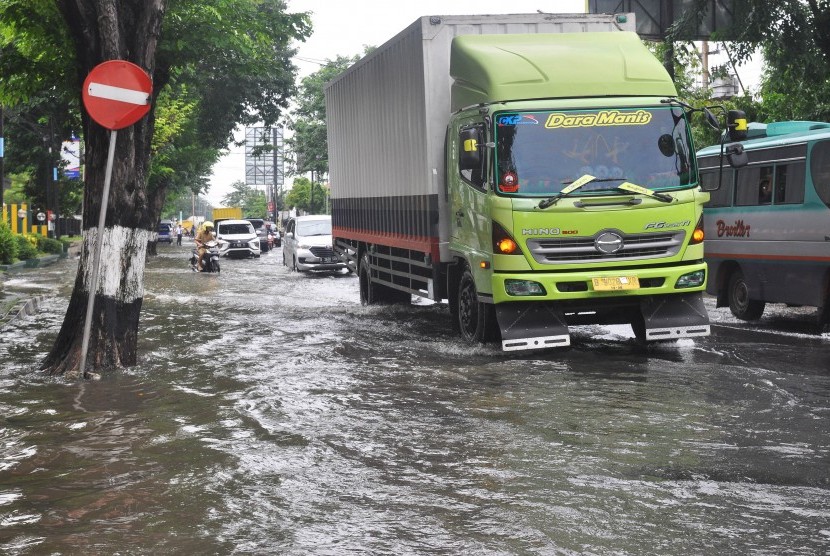 Sejumlah kendaraan berjalan perlahan saat melintasi banjir di jalur pantura kota Kendal, Jawa Tengah, Senin (28/1/2019).