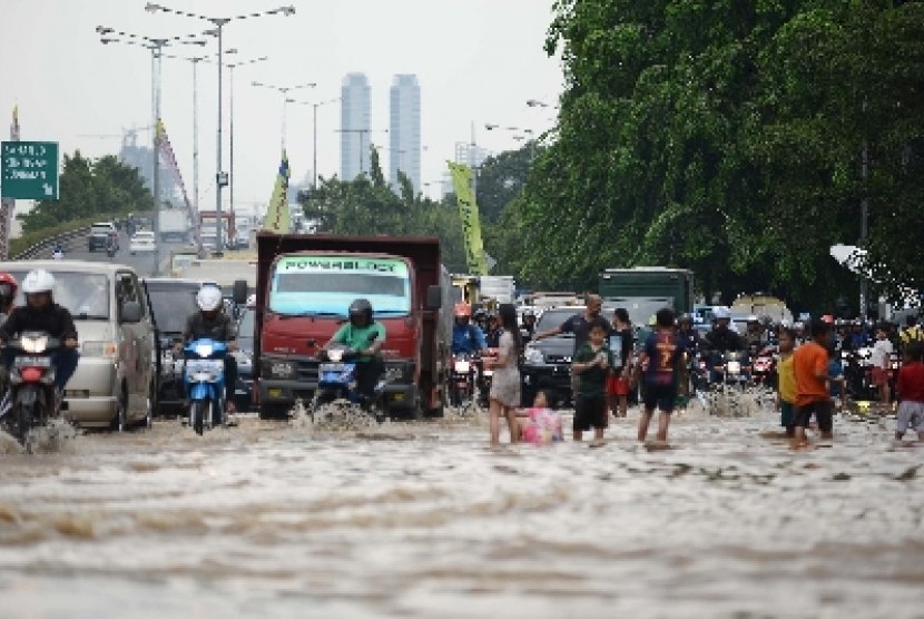 Sejumlah kendaraan berjalan perlahan terhambat oleh air luapan Sungai Ciliwung di Jalan Jatinegara Barat, Jakarta Timur, Kamis (20/11). 