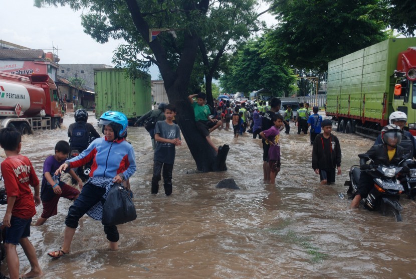 Sejumlah kendaraan dan pejalan kaki berusaha melintasi banjir di depan Pabrik Kahatex kawasan Rancaekek, Kabupaten Bandung, Jawa Barat, Selasa (1/11).