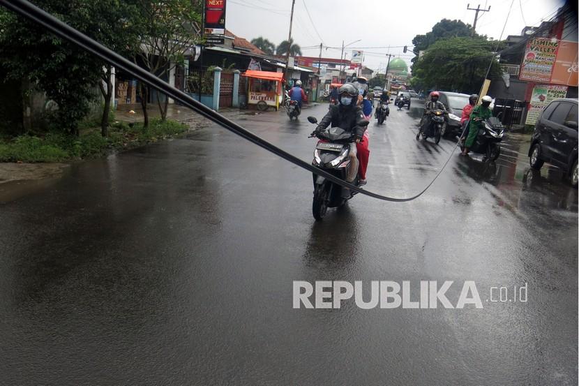 Sejumlah kendaraan melaju di antara kabel optik yang menjuntai di jalan (ilustrasi).