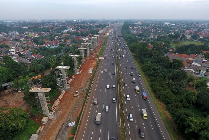 Sejumlah kendaraan melaju di samping deretan tiang konstruksi proyek kereta api ringan atau Light Rail Transit (LRT) rute Cibubur-Cawang di samping jalan tol Jagorawi kawasan Cibubur, Jakarta, Rabu (7/12).