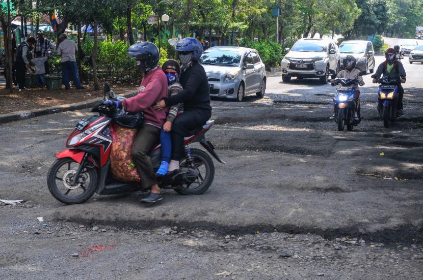 Sejumlah kendaraan melewati jalan rusak di jalan I Gusti Ngurah Rai, Bekasi, Jawa Barat.
