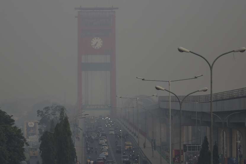 Sejumlah kendaraan melintas di atas Jjembatan Ampera yang diselimuti kabut asap di Palembang, Sumatra Selatan, Ahad (16/9/2023). Meski Sumatra dan Kalimantan penuh asap, namun Batam dinyatakan aman.