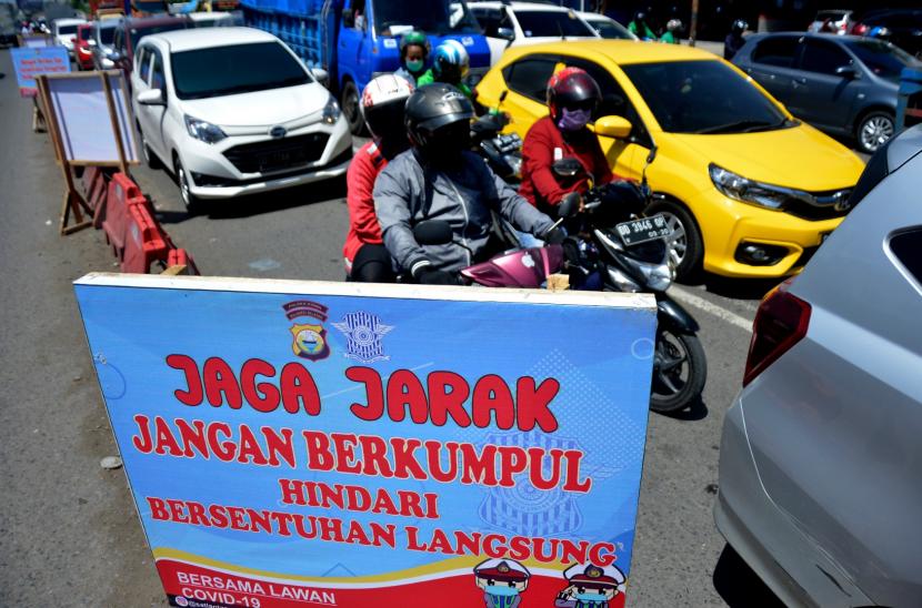 Sejumlah kendaraan melintas di dekat papan imbauan menjaga jarak di Kabupaten Gowa, Sulawesi Selatan, Kamis (23/4/2020). Pembatasan Sosial Berskala Besar (PSBB) di Kabupaten Gowa akan diterapkan mulai Rabu (29/4).