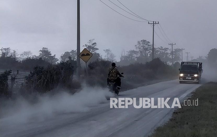Sejumlah kendaraan melintas di jalan yang dipenuhi debu vulkanik pascaerupsi Gunung Sinabung, di Desa Sigarang-garang, Karo, Sumatera Utara, Sabtu (8/8/2020). Gunung Sinabung erupsi dengan tinggi kolom 2.000 meter. 