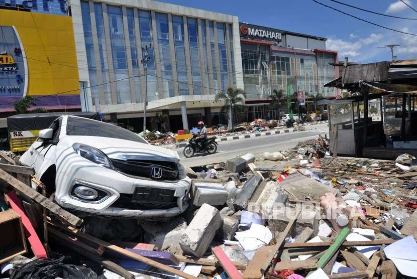 Sejumlah kendaraan melintas di kawasan yang terdampak gempa dan tsunami di Palu, Sulawesi Tengah, Jumat (5/10).