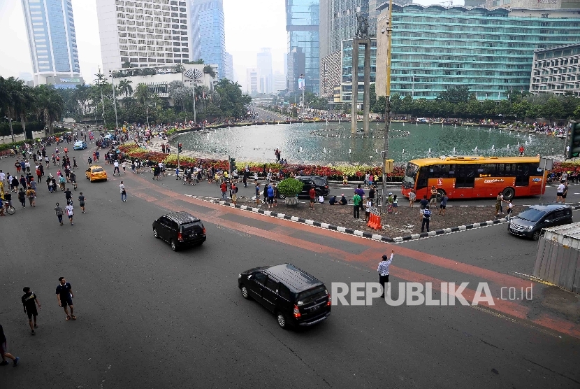  Sejumlah kendaraan melintas di antara warga yang berolah raga di Bunderan Hotel Indonesia, Jakarta (ilustrasi) 
