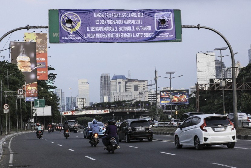 Sejumlah kendaraan melintas dibawa papan pemberitahuan Uji Coba Penghapusan Kawasan 3in1 di kawasan Jalan Gatot Subroto, Jakarta, Minggu (3/4).ANTARA FOTO/Muhammad Adimaja