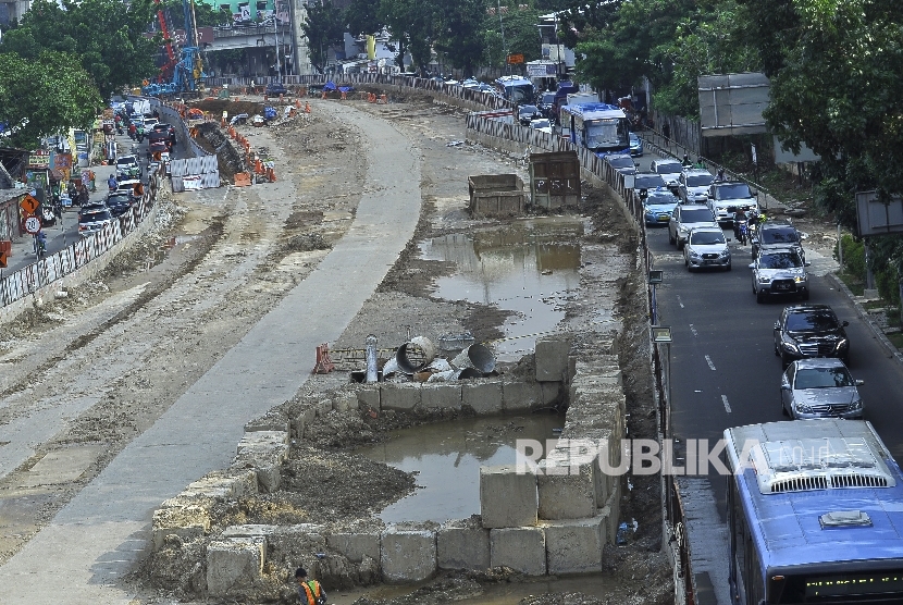 Sejumlah kendaraan melintas disamping proyek pembangunan underpass masih dalam proses penyelesaian di Kawasan Mampang, Jakarta Selatan, Senin (3/7). 