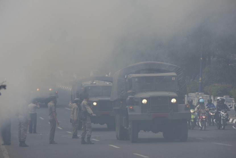Sejumlah kendaraan melintasi asap di Jembatan Tugu 66, Jakarta, Rabu (19/8).     (Antara/Rosa Panggabean)