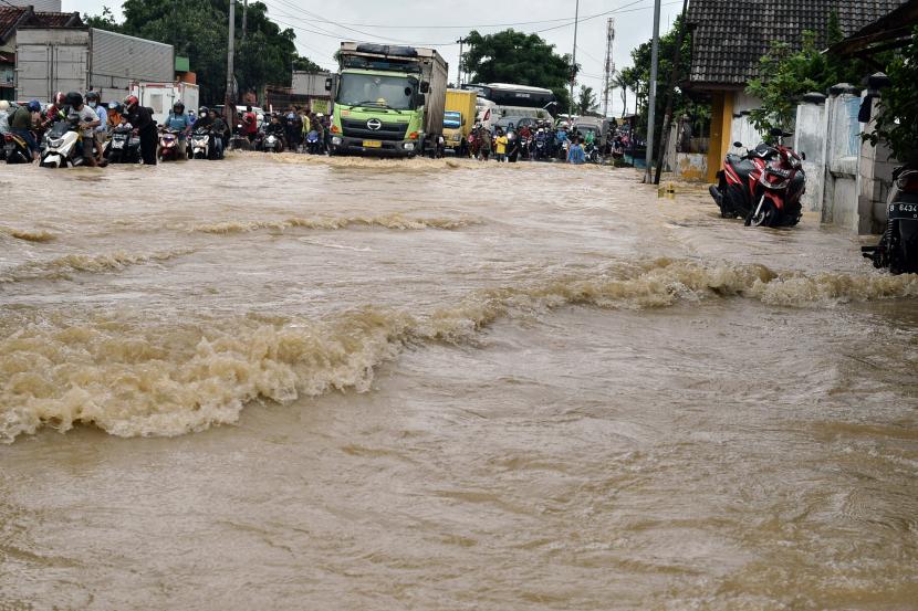 Sejumlah kendaraan melintasi banjir yang merendam Jalan Raya Lemah Abang, Cikarang Utara, Bekasi, Jawa Barat. Sebanyak 130 rumah di Cikarang Utara, Kabupaten Bekasi terendam banjir setinggi 80 cm.