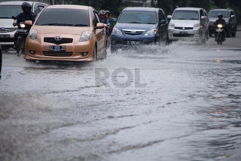 Sejumlah kendaraan melintasi genangan air yang berada di Jalan Gatot Subroto, Jakarta Pusat, Senin (10/3).  (foto : Raisan Al Farisi)