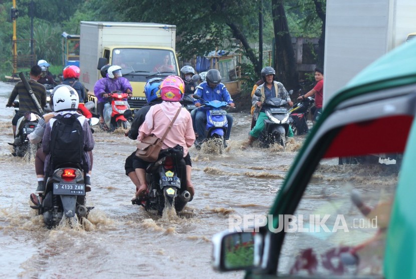 Sejumlah kendaraan melintasi genangan air yang mulai membanjiri Jalan Anggadireja, Kecamatan Baleendah, Kabupaten Bandung, Kamis (8/11).