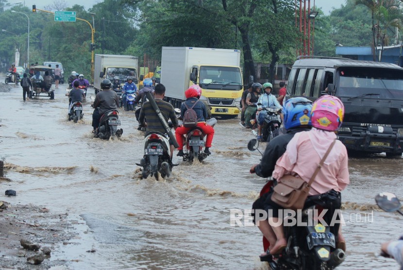 Sejumlah kendaraan melintasi genangan air yang mulai membanjiri Jalan Anggadireja, Kecamatan Baleendah, Kabupaten Bandung, Kamis (8/11).