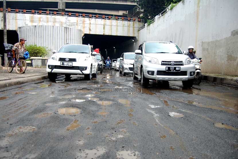 Sejumlah kendaraan melintasi jalan rusak di underpass Pasar Gembrong, Jakarta Timur, Jumat (28/2). (foto : Raisan Al Farisi)