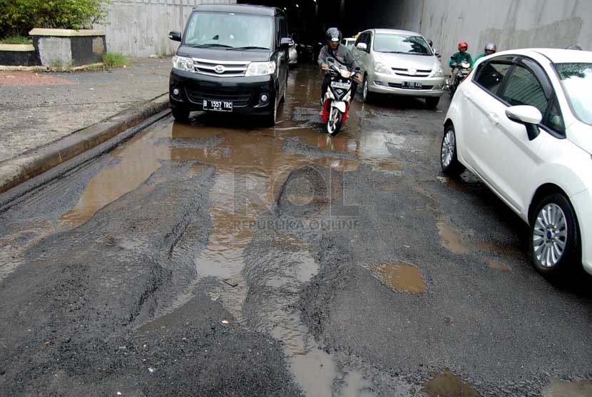 Sejumlah kendaraan melintasi jalan rusak di underpass Pasar Gembrong, Jakarta Timur, Jumat (28/2). (foto : Raisan Al Farisi)